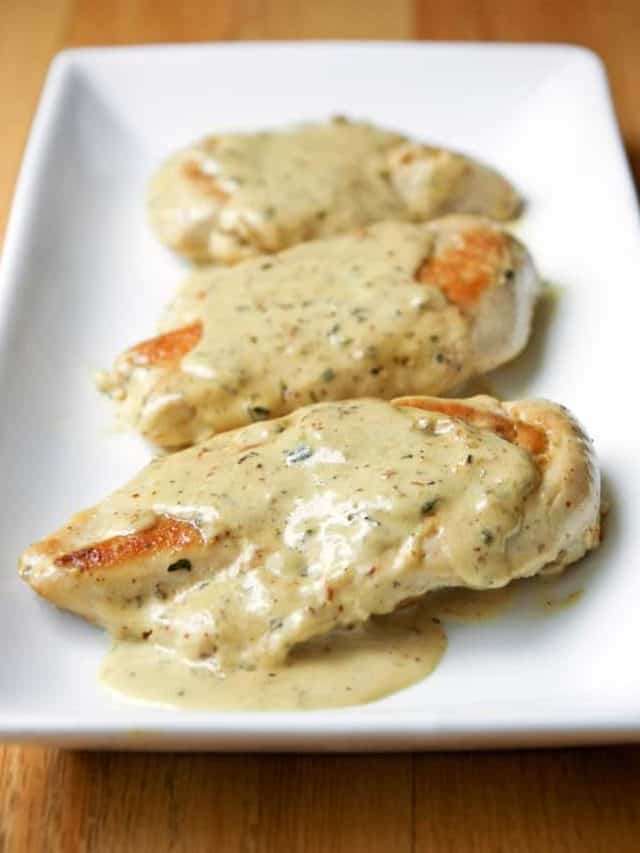 Chicken breasts on platter with mustard cream sauce.