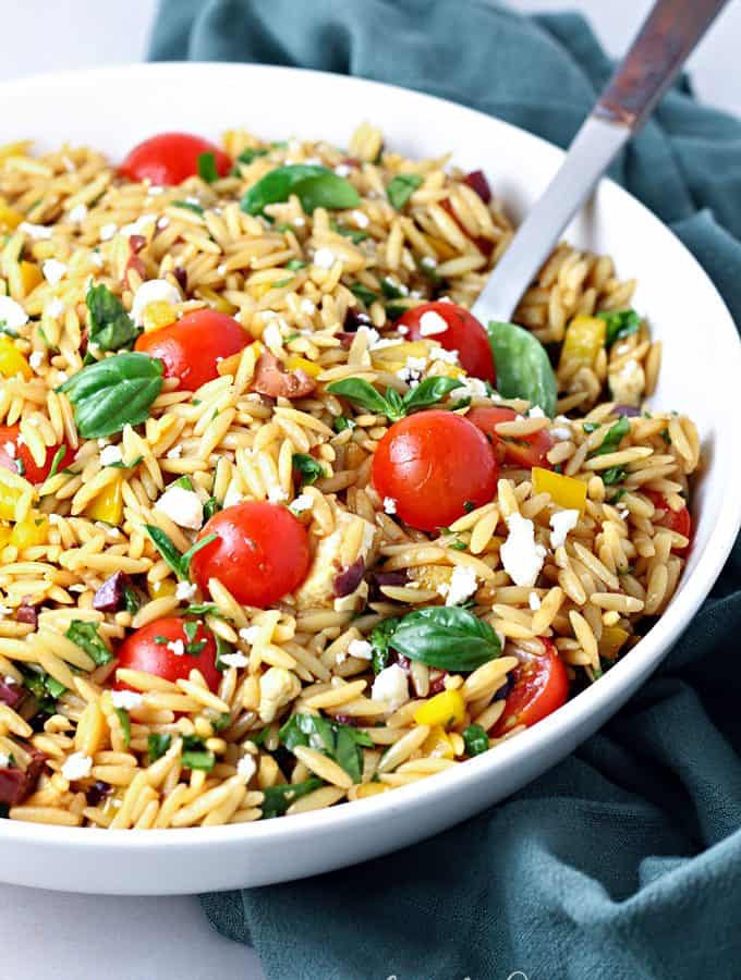 Mediterranean orzo salad with tomatoes, olives, feta and herbs.