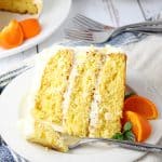 Slice of pineapple orange cake with whipped cream frosting.