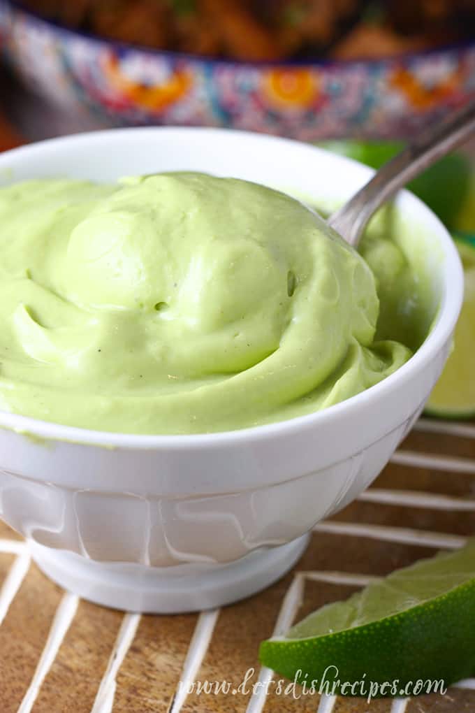 Creamy avocado sauce in bowl with spoon.