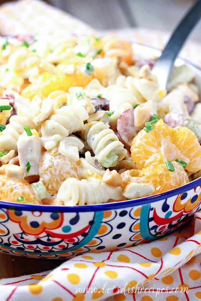 Pasta salad with chicken, pineapple and mandarin oranges in colorful bowl.